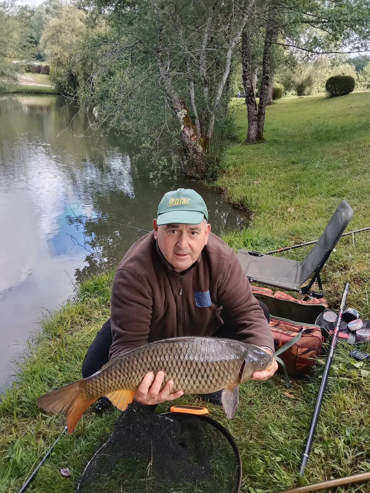 Pêcheur du camping fier de sa carpe pêchée dans les étangs de Plessac